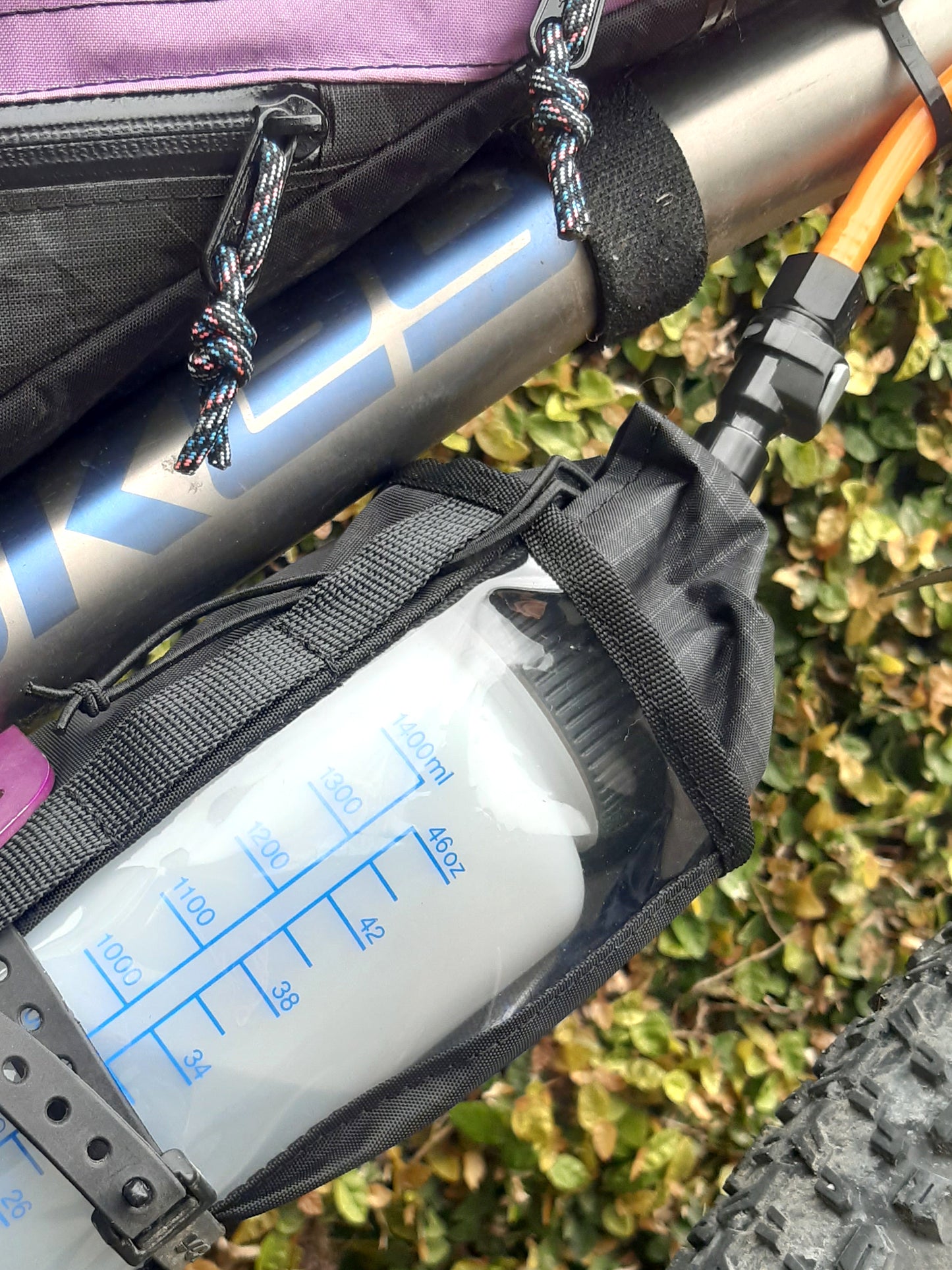Mountain bike hydration system Nalgene bottle and drinking hose under bike frame for bikepacking, water bladder replacement.