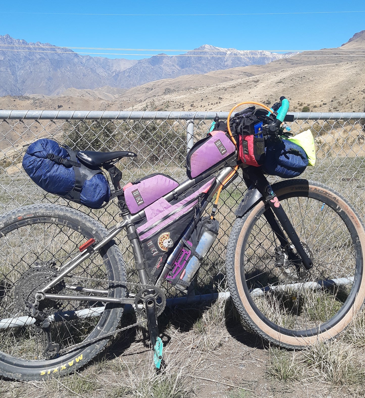 Mountain bike hydration system bottle and drinking hose under bike frame for bikepacking, water bladder replacement.