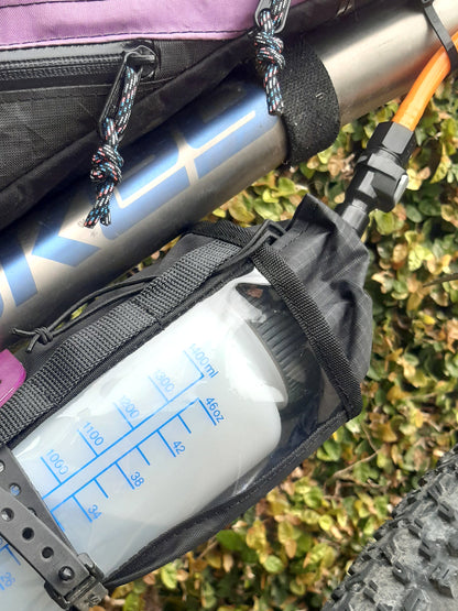 Mountain bike hydration system Nalgene bottle and drinking hose under bike frame for bikepacking, water bladder replacement.