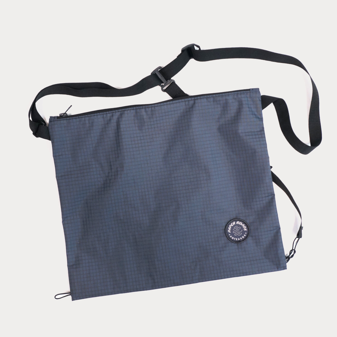 Cycling biking bikepacking touring musette. Small packable shoulder bag for shopping or commuting. Made in New Zealand by Paper Roads Aotearoa. Colourful, souvenir, gift. Blue grey colour.